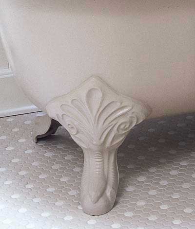 detailed foot of clawfoot tub in vintage-style bathroom