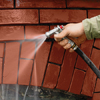 washing away mortar debris from a brick wall