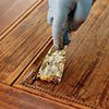 A dull scraper is the best tool for removing stripper-softened finish from flat panels