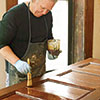 John Thomas brushes on a final coat of satin spar varnish