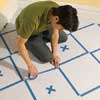 masking the checker pattern on a floor with painter's tape