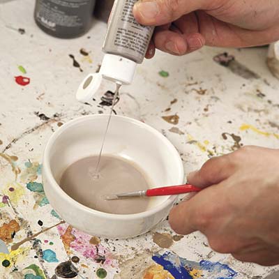 paint being mixed with water in a bowl