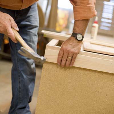Tom Silva nailing furring strips to the unfinished ends of the joined cabinets