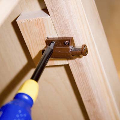 Tom Silva mounting door latches to the inside of the cabinet doors