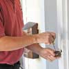 man unscrewing a doorbell button