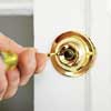 man reattaching a doorbell button