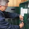 Lance Marques connects the thermostat power wire to the furnace