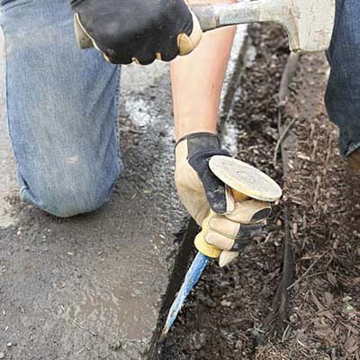 removing rough edges from a newly cut asphalt driveway edge