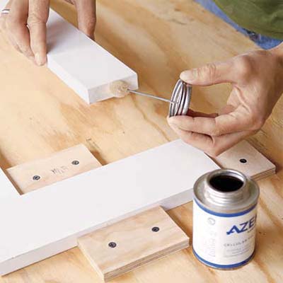 hands applying glue to fix together the sides of this all weather planter