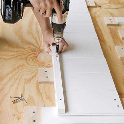 hands attaching the cut ledges for the bottom boards of this all weather planter