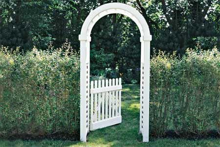 arched garden arbor standing between hedges on a lawn