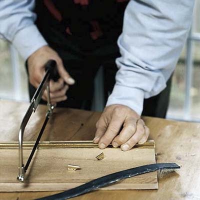 using a hacksaw to trim a squeegee to fit a specific windowpane