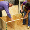 Tom Silva and Amy Paladino install the rail for the tool bench outer frame