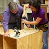 Tom Silva and Amy Paladino assemble the base of the tool bench