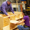 Tom Silva and Amy Paladino sliding shelves into the tool bench