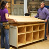 Tom Silva and Amy Paladino install the work surface area onto the top of the tool bench