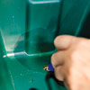 woman making hole in planter bottom