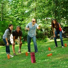 four people playing kubb in yard