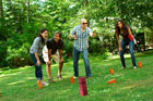 four people playing kubb in yard
