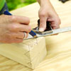 man marking wood to make king crown for yard game of kubb