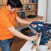 Mark Powers uses a miter saw to cut pieces for a bar cart