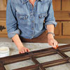 woman prepares salvaged window sash