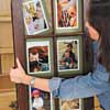 woman arranges the matted photos to the back side of the window