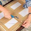 woman adds hanging hardware to picture frame