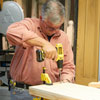 Tom Silva drills holes in the shelves