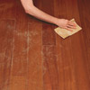 hand sanding wood floor in preparation for painting