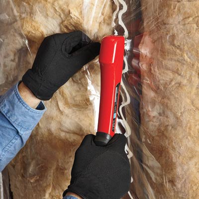 man installing vapor retarder over batt insulation