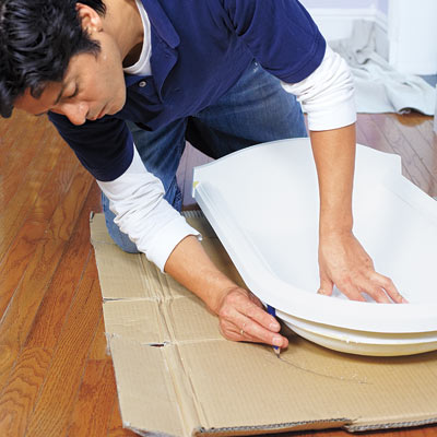 man tracing wall niche to create template for installation