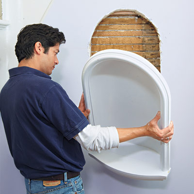 man setting wall niche in place