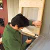 Mark Powers fastening a lid to the top of his trash shed