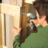 Mark Powers fastening the front doors onto his trash shed