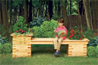 child enjoying a seat on an outdoor planter bench on a beautiful day