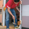 Mark Powers installs a door on an office cubicle