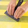 combing the herringbone pattern with a modified plastic putty knife