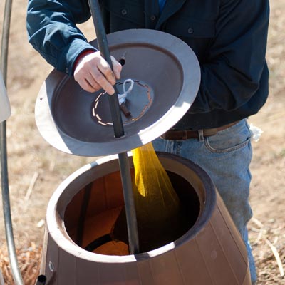 attaching the compost bag to the lid of a rain barrel