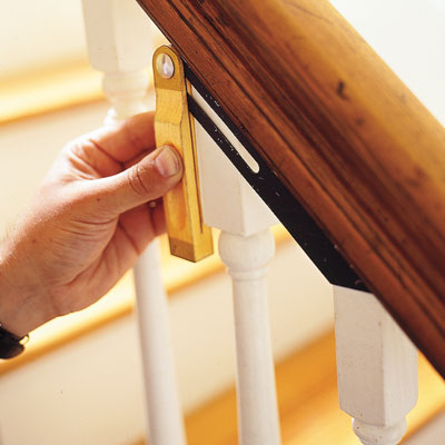using a T-bevel to measure the top angle of the railing on a stairway