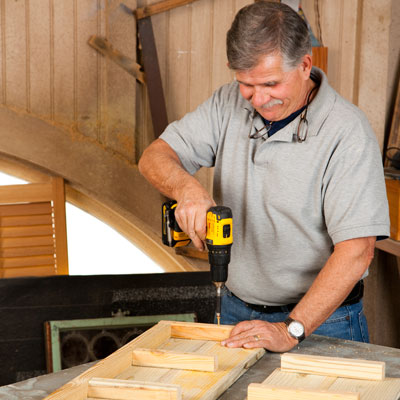 Tom Silva attaching 2x2 corner blocks to the side boards with a drill/driver