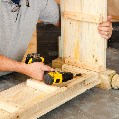 Tom Silva attaching the sides to the corner leg with a drill/driver