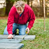 measuring to lay out the distance between each paver in stepping stone path 