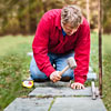 placing the paver stone in the setting bed and pounding it with a rubber mallet for a stone stepping path 