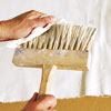 wiping excess glaze from the stiff-bristled brush with a clean rag