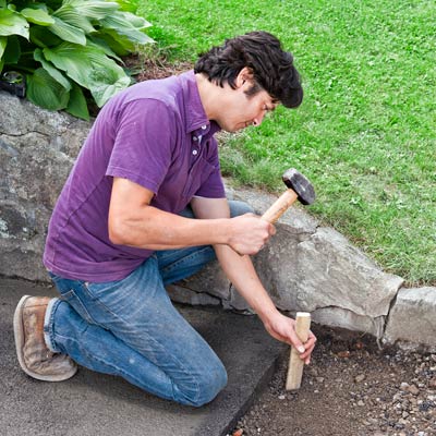 checking the depth of an area of removed driveway