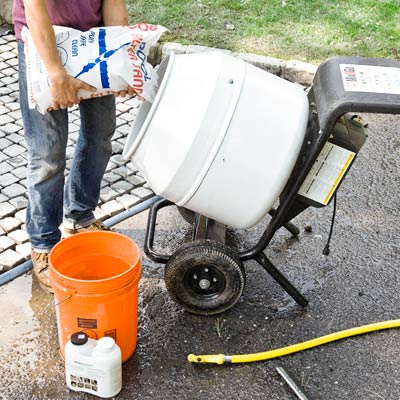 mixing grout to add between a cobblestone driveway apron
