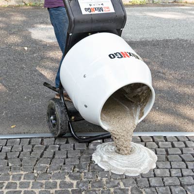 spreading grout onto a cobblestone driveway apron