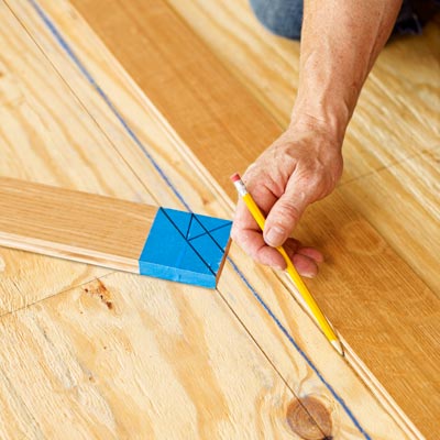 marking the subfloor for a herringbone floor using the marked wood slat