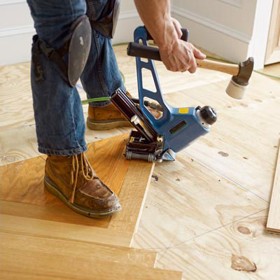 fastening the wood slats for the second course of a herringbone floor with a flooring nailer